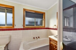 Bathtub, hair dryer, towels, shampoo
