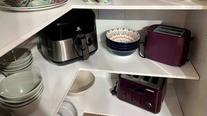 Une cuisine équipée de divers appareils et ustensiles, notamment une machine à café, un grille-pain et des bols.