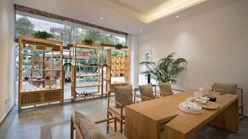 Un comedor moderno con mesa de madera, sillas y un amplio ventanal con vistas.