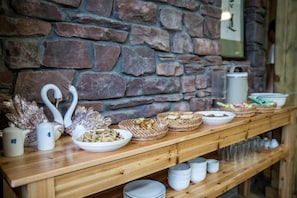 Une table de buffet garnie de divers plats et agrémentée d’un centre de table en forme de cygne.