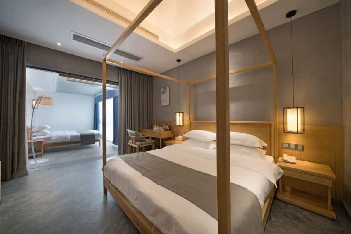 Una habitación de hotel moderna con una cama con dosel, un escritorio y una silla.