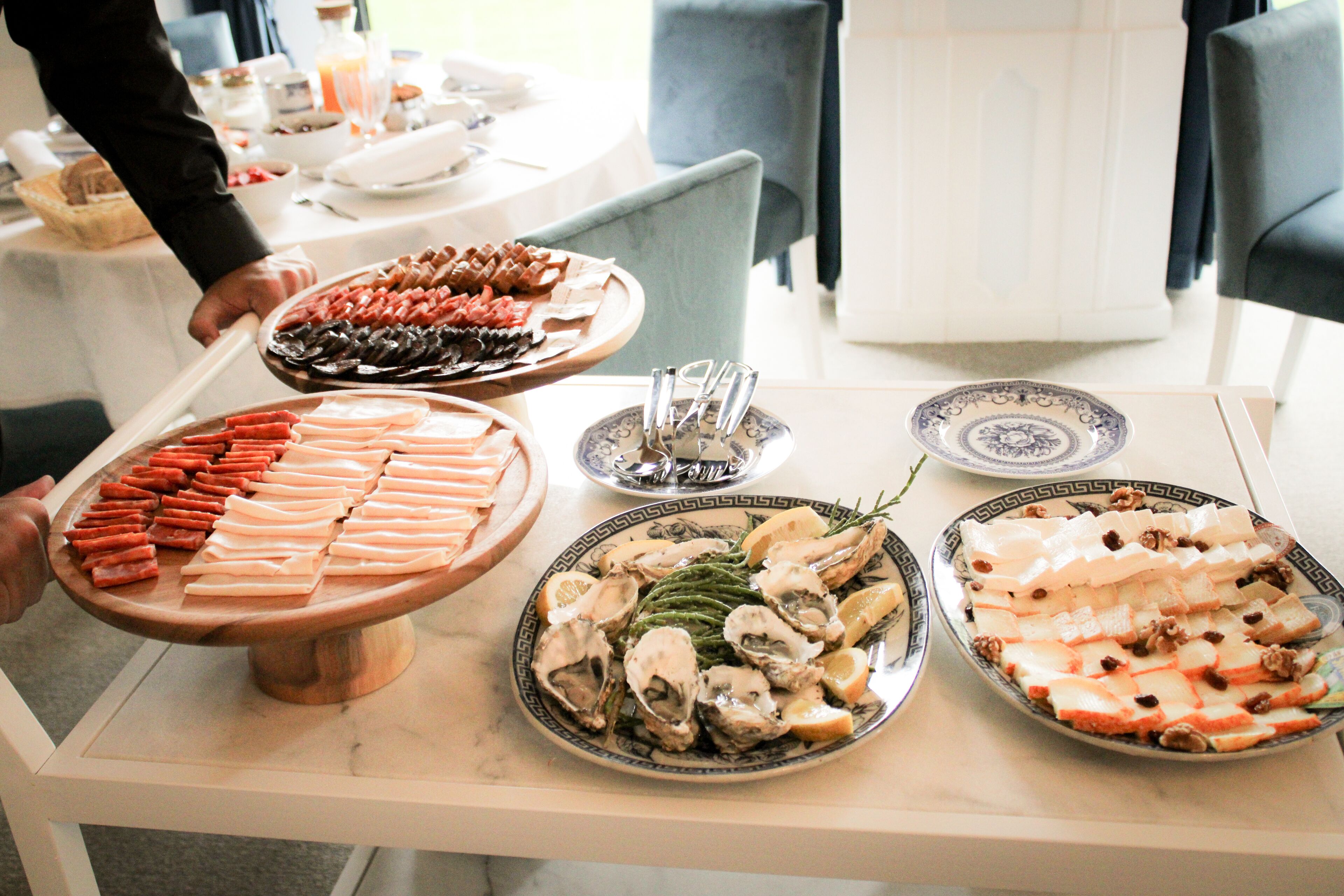 A buffet table with various food items including meats, cheeses, and seafood.