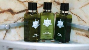 Three bottles of bath products on a shelf. - edinburgh hotel (Haining)