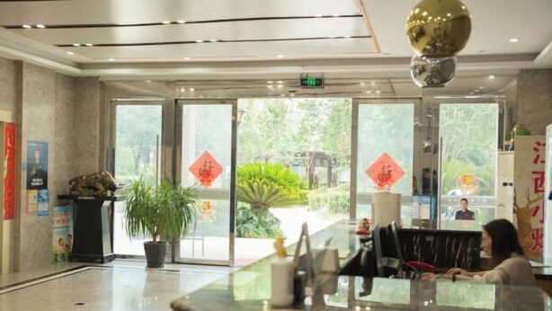 A reception area with a marble counter, potted plants, and a large decorative globe. - edinburgh hotel (Haining)