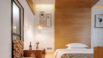 Un dormitorio moderno con techo de madera, una cama con ropa blanca, una mesita de noche de madera y un marco de fotos colgado en la pared.