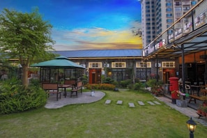 Un patio con un mirador, asientos exteriores y un edificio con restaurante.