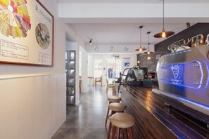 A bar area with stools, a neon sign, and a wall-mounted menu board. - Hanshe Inn (Hangzhou)