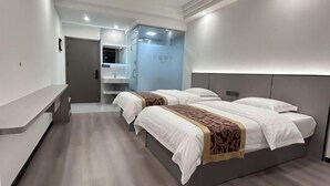 Una camera d'hotel moderna con un letto grande, un comodino, uno specchio e un bagno sullo sfondo.