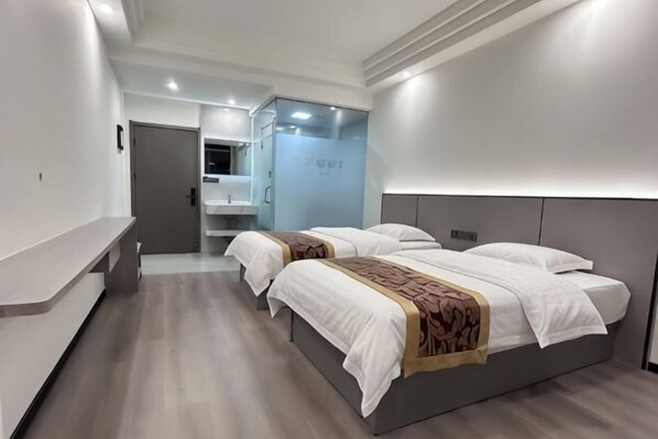 A modern hotel room with a large bed, a bedside table, a mirror, and a bathroom visible in the background. - Qingcheng Express Hotel (Ma'anshan)
