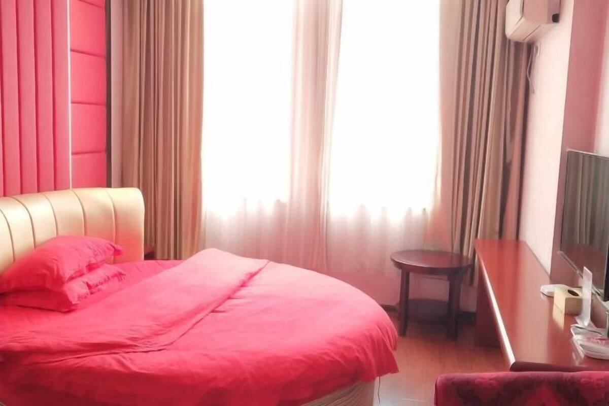 A hotel room with a bed, a desk, and a chair.