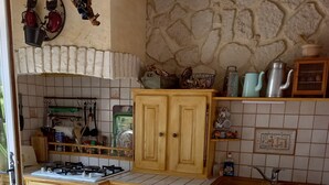 Uma cozinha compacta com armários de madeira, fogão, geladeira e pia.