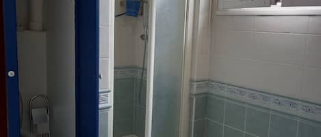 A bathroom with a shower, toilet, and sink.