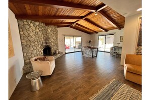 Relax in this inviting living area with a high ceiling, stone wall, and comfortable seating.