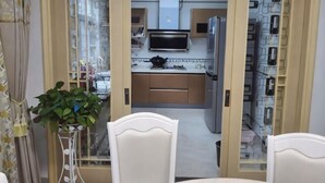 A view through a doorway into a kitchen with cabinets, a microwave, and a plant.