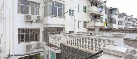 A multi-story residential building with balconies, air conditioning units, and a gated entrance.