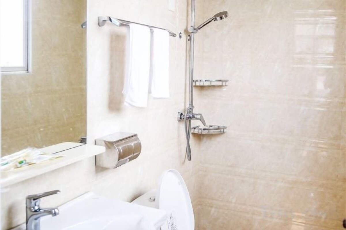 A bathroom with a toilet, sink, and shower.