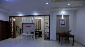 A spacious living area with a dining table, a sofa, and a decorative wall.