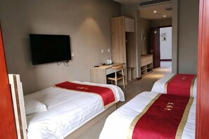 Una habitación de hotel con dos camas, televisión, escritorio y armario.