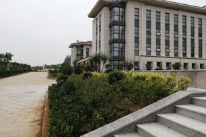 Een modern gebouw met een plat dak, grote ramen en een verharde looppad.