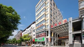 Ein mehrstöckiges Gebäude mit Geschäftsflächen im Erdgeschoss, darunter ein Restaurant und eine Apotheke.