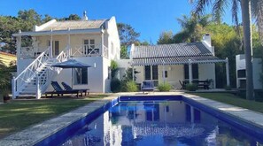 Enjoy a relaxing stay in this two-story house with a balcony and covered patio, perfect for lounging by the pool.