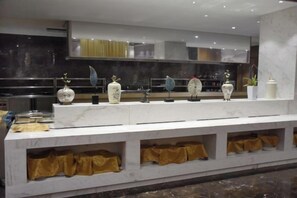 A marble counter with decorative vases and a modern kitchen in the background.