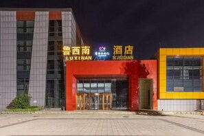 Entrada de hotel con fachada moderna, señalización destacada y acceso mediante portón.