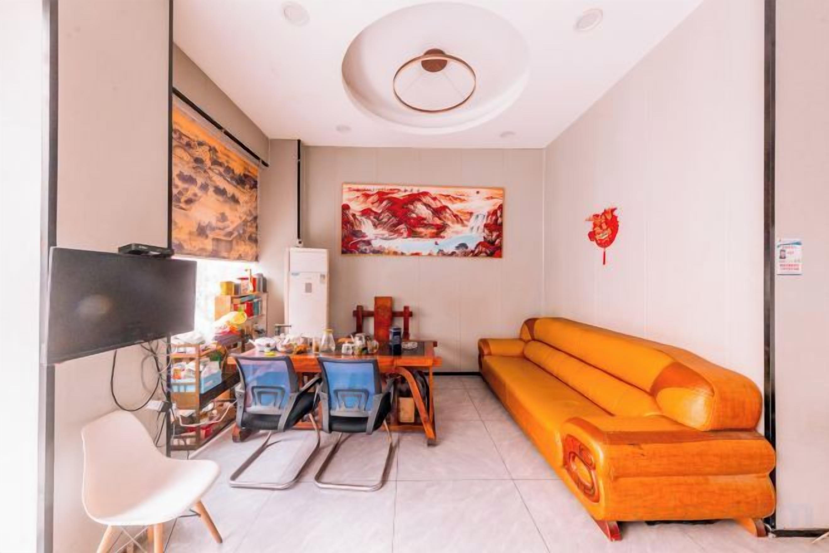 A compact living space with a sofa, a dining table, and a television.