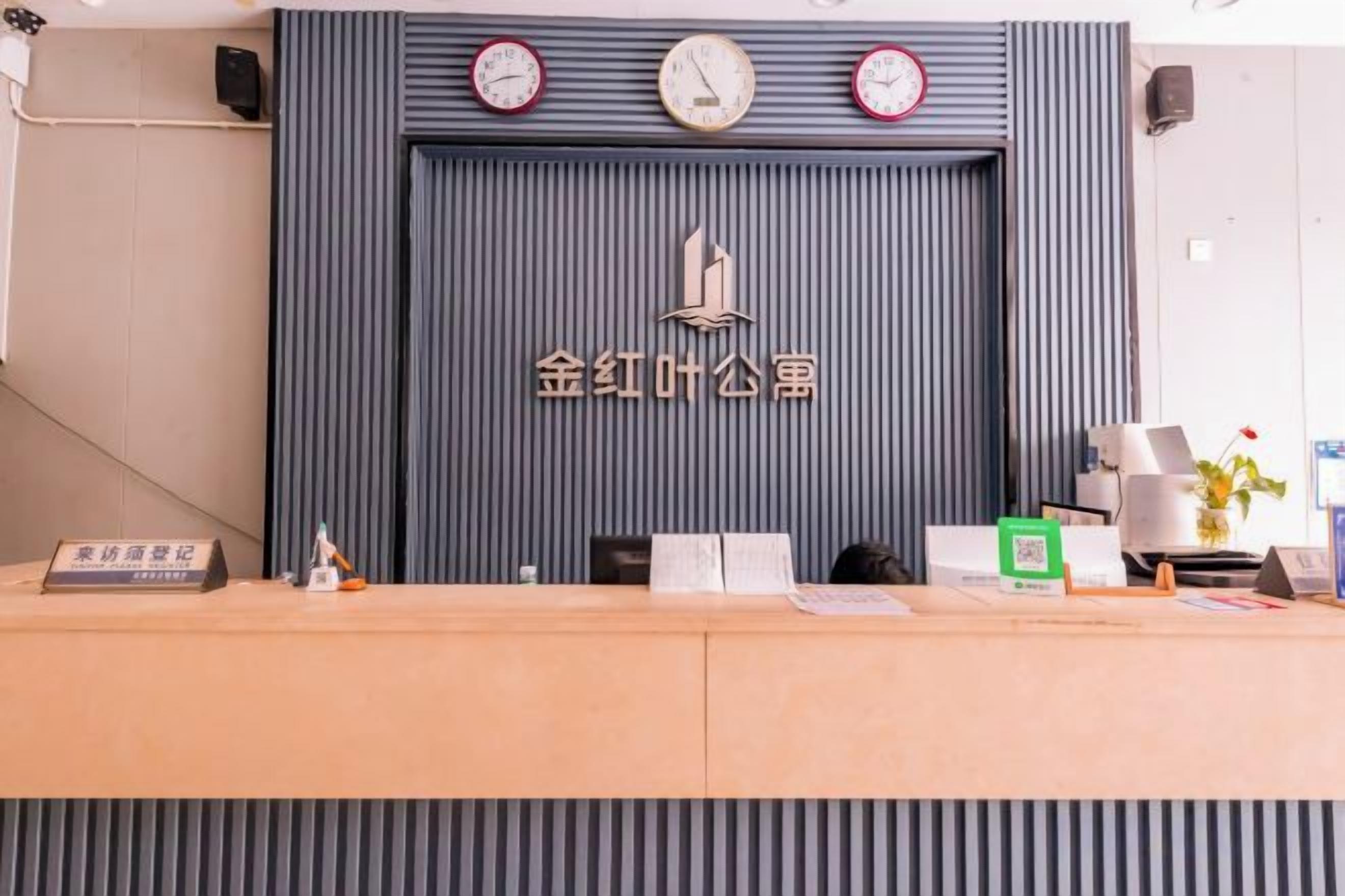Una mesa de recepción con un reloj, un logotipo y algunos útiles de escritorio.