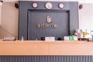 Un comptoir d’accueil avec une horloge, un logo et quelques fournitures de bureau.