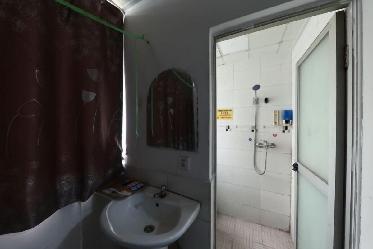 Un baño con lavamanos, ducha e inodoro.