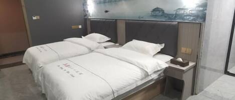 A hotel room with a bed, a nightstand, and a wall mural.