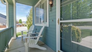 A porch with two Adirondack chairs, a door with a glass panel, and a wall-mounted light fixture. - ☀Cheerful Family Getaway ~ Large & Sunny Backyard☀ (Sparks)