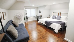 A bedroom with a bed, a sofa, a desk, and a fan. - Private Patio W/ Grill + Game Room - Sleeps 10! (Wichita)