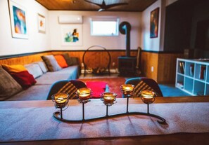 A cozy living room with a sofa, a coffee table with candles, and a fireplace. - Dream getaway apartment in the foot of Gunks Ridge (Wallkill)