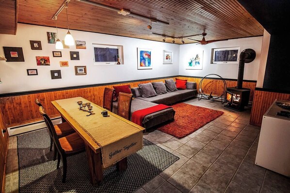 A cozy living area with a wooden bench, a sofa, and a table with a 'Gather Together' sign. - Dream getaway apartment in the foot of Gunks Ridge (Wallkill)
