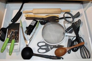 A drawer containing various kitchen utensils including a rolling pin, spatulas, a strainer, and a whisk. - Dream getaway apartment in the foot of Gunks Ridge (Wallkill)