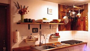 A kitchen with wooden countertops, a stainless steel sink, hanging pots, and a wooden shelf with various items. - Dream getaway apartment in the foot of Gunks Ridge (Wallkill)