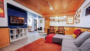 A cozy living room with a sofa, a television, and a bookshelf. - Dream getaway apartment in the foot of Gunks Ridge (Wallkill)