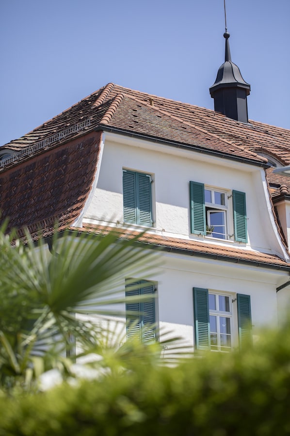 A two-story building with a tiled roof and a chimney.
