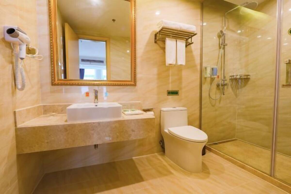 A modern bathroom with a sink, toilet, and shower.