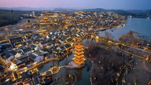 A traditional village with a prominent pagoda and a river. - Vienna Hotel (Yixing High-speed Railway Station) (Yixing)
