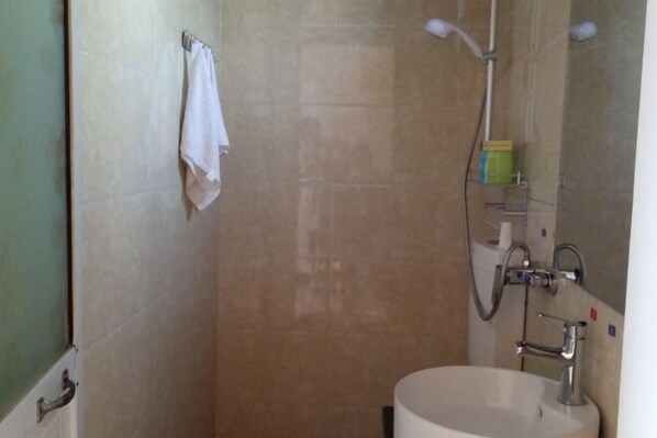 A bathroom with a shower, a sink, and a towel rack. - Qingcheng Mountain Qingcheng House Inn (Dujiangyan)
