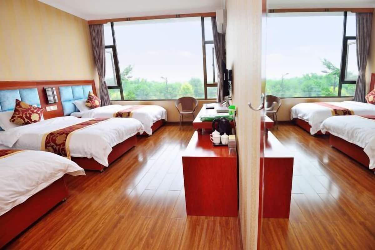 A hotel room with two beds, a desk, and a chair.