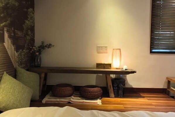 A cozy bedroom with a bed, pillows, a bedside table with a lamp, and a window with blinds. - Zhangshe Courtyard Hotel (Hangzhou)