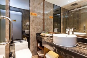 Une salle de bain moderne avec un grand miroir, un lavabo blanc et des toilettes.