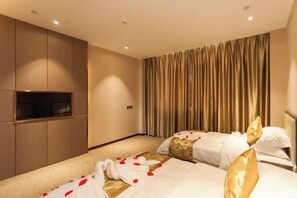 Une chambre d’hôtel avec deux lits, un minibar et une grande fenêtre avec des rideaux.