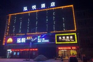 Un hotel con letreros iluminados y una entrada destacada.