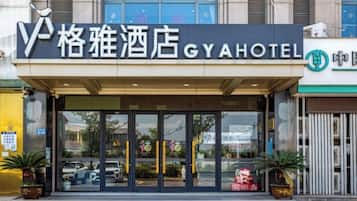 Entrada de un hotel con un cartel que dice 'GYA HOTEL' y un logotipo.