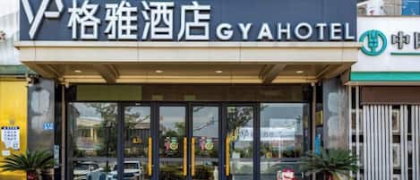 Entrada de un hotel con un cartel que dice 'GYA HOTEL' y un logotipo.